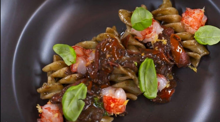 Fusilloni al nero di seppia, pomodorini e gamberi