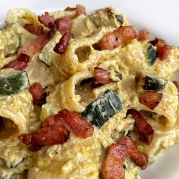 Pasta con pesto di pistacchi e ricotta, zucchine e pancetta croccante